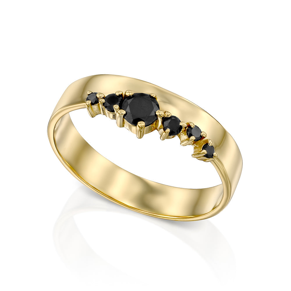 A wide gold ring with a special asymmetrical setting of black diamonds
