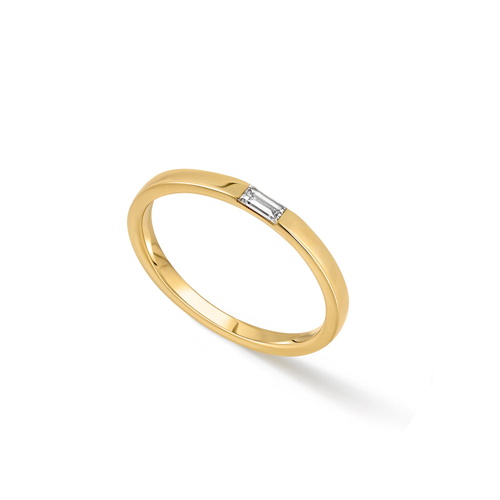 A thin flat gold ring set with a baguette-cut laboratory diamond