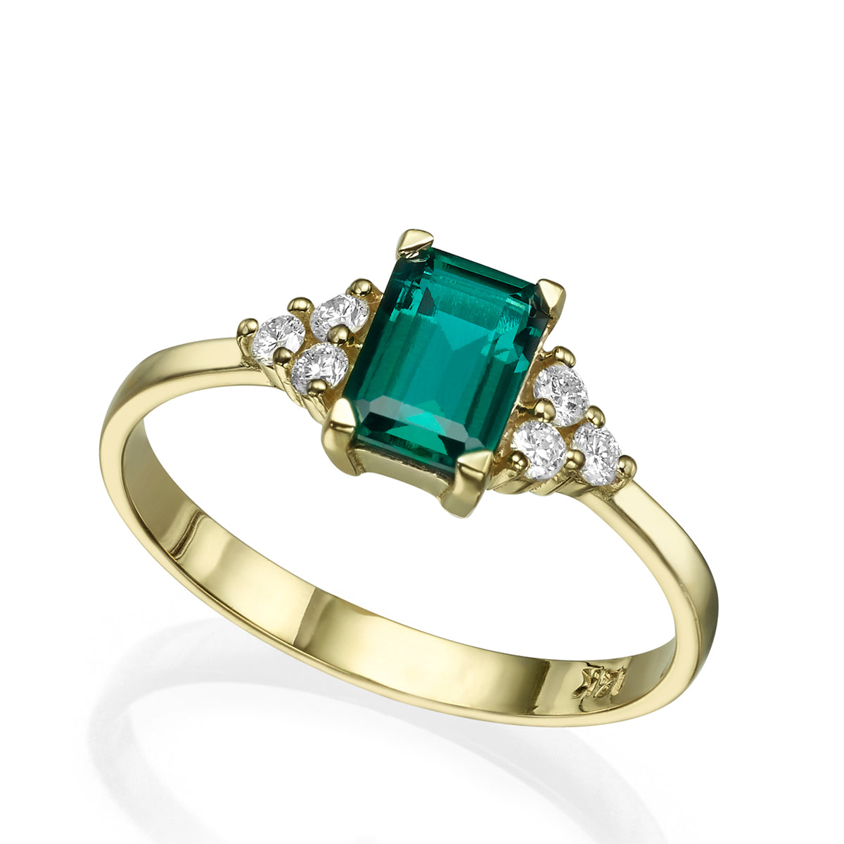 An engagement ring set with a rectangular lab emerald and 6 sided diamonds