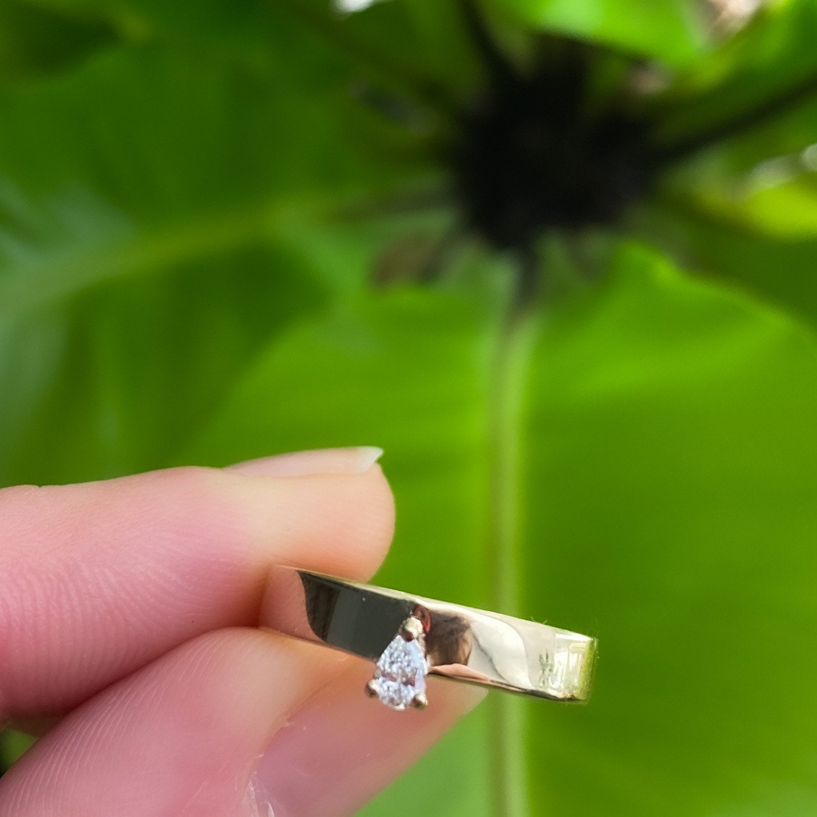 Modern smooth gold ring set with a drop cut diamond