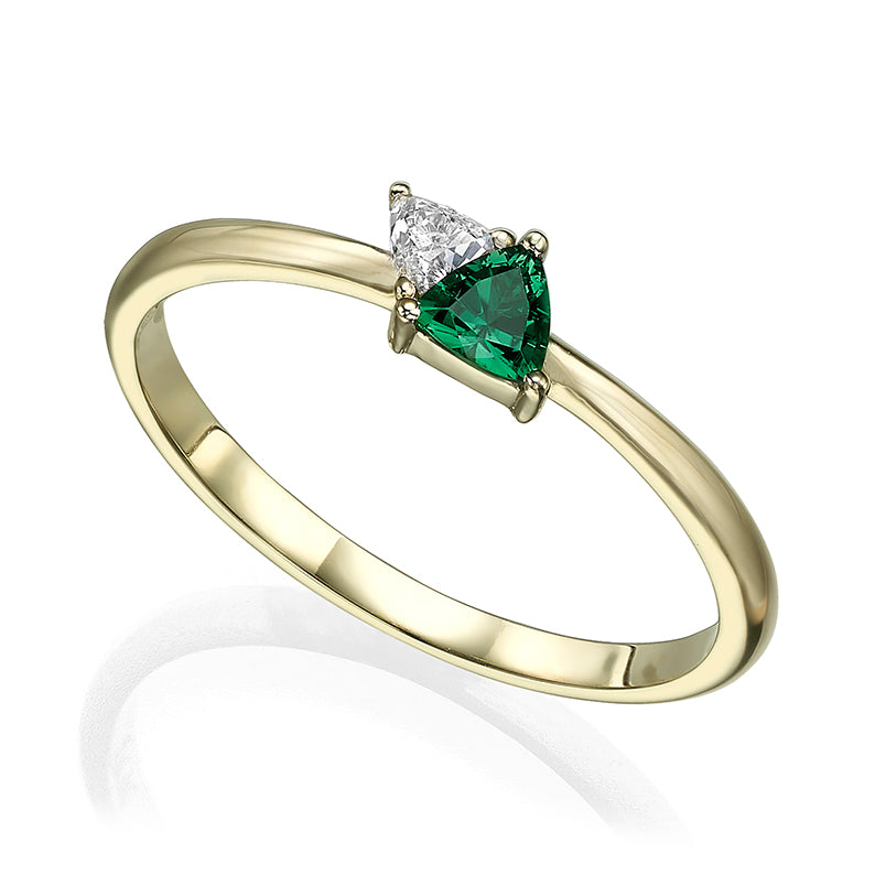 A gold ring set with a diamond and green tourmaline in a trillion cut