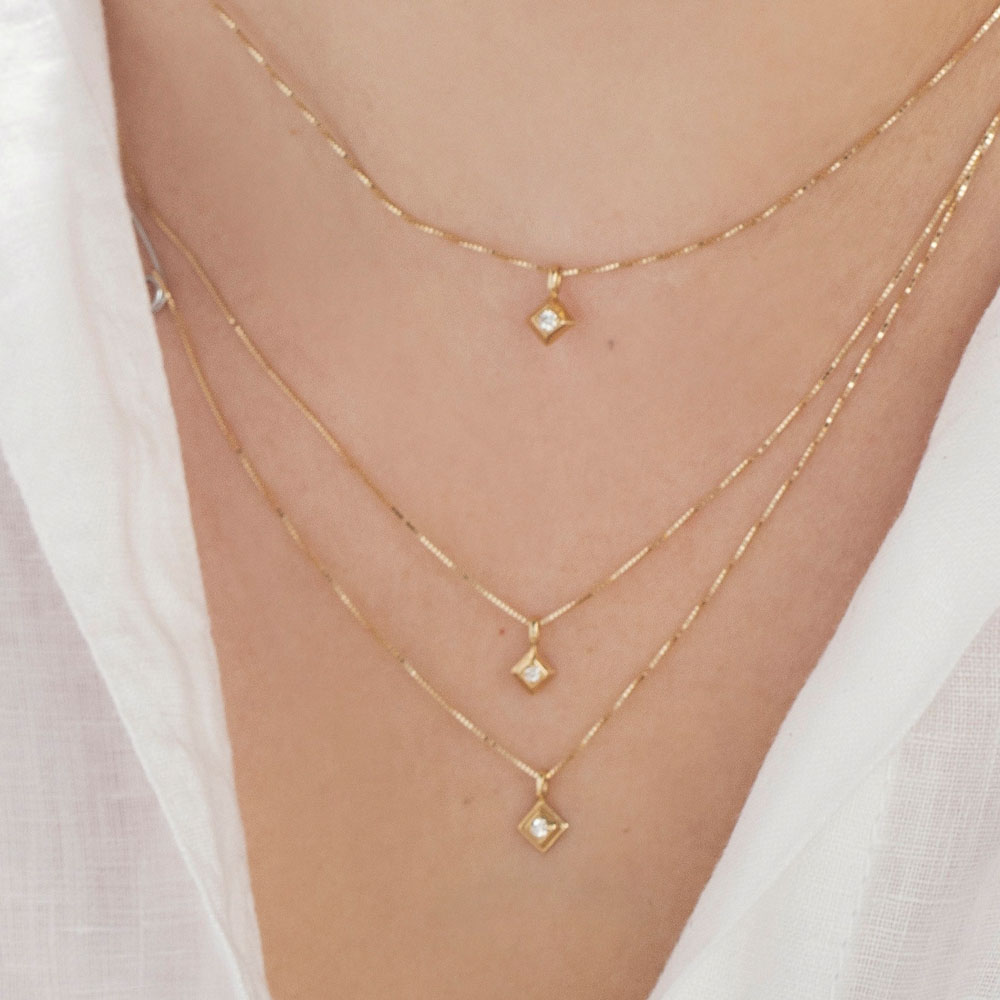Fine gold necklace with a small square pendant and a 1.5 point diamond