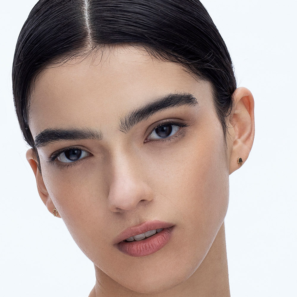 Gold Hamsa earrings close to the ear