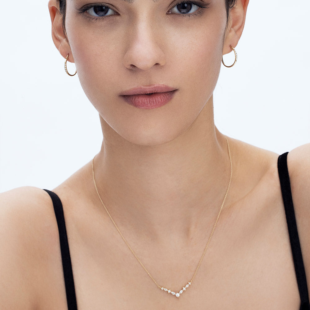 Delicate gold hoop earrings set with a row of 5 diamonds of different sizes