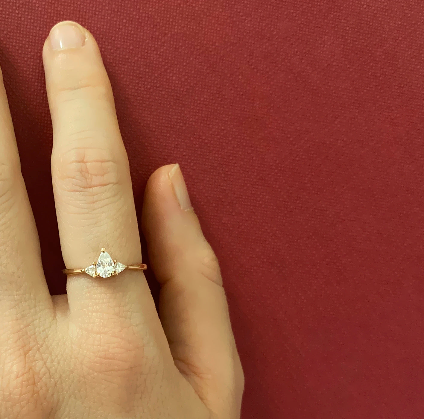 An engagement ring set with a central drop-cut diamond and triangular-cut diamonds on the sides