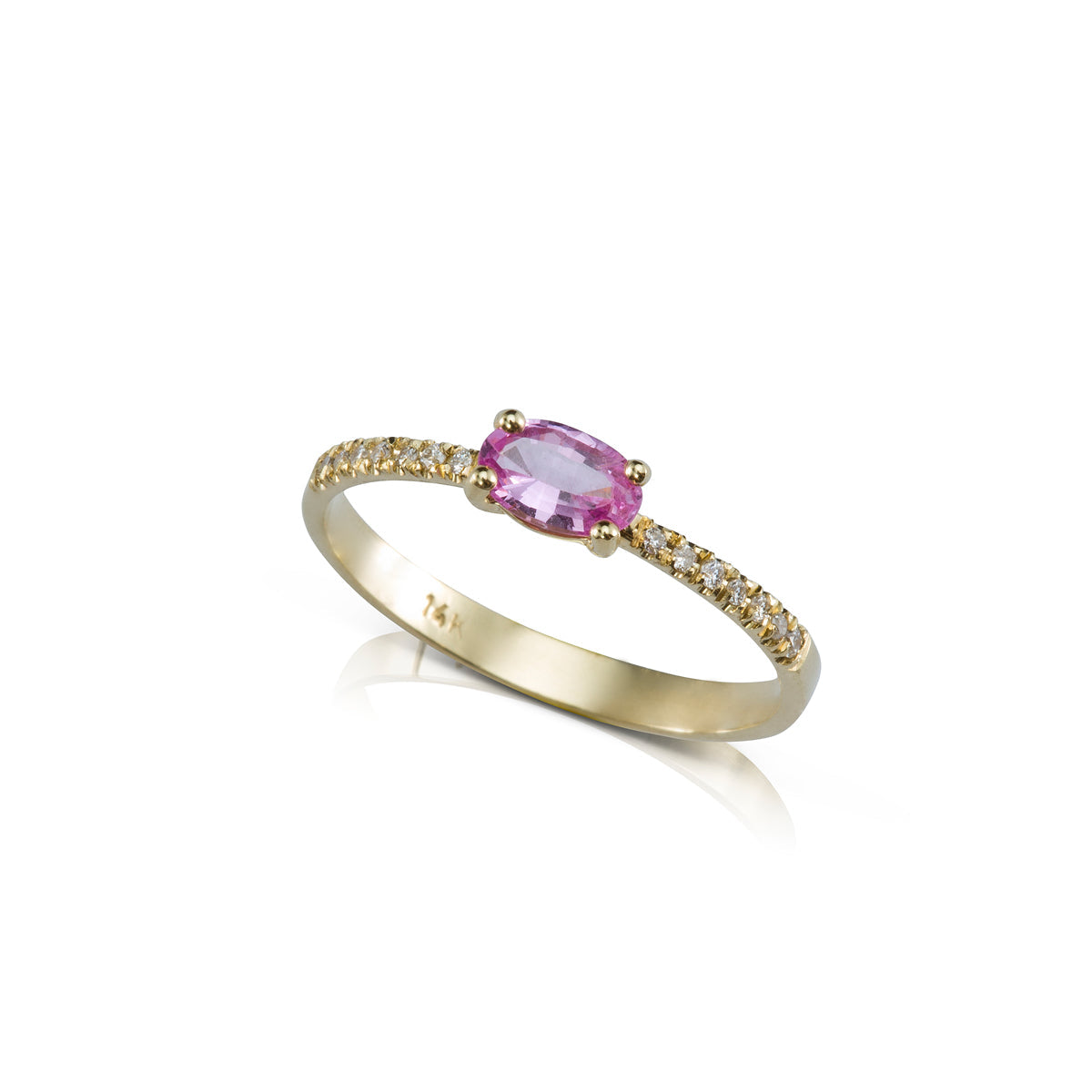 A gold ring set with an oval pink sapphire and a row of diamonds on the sides