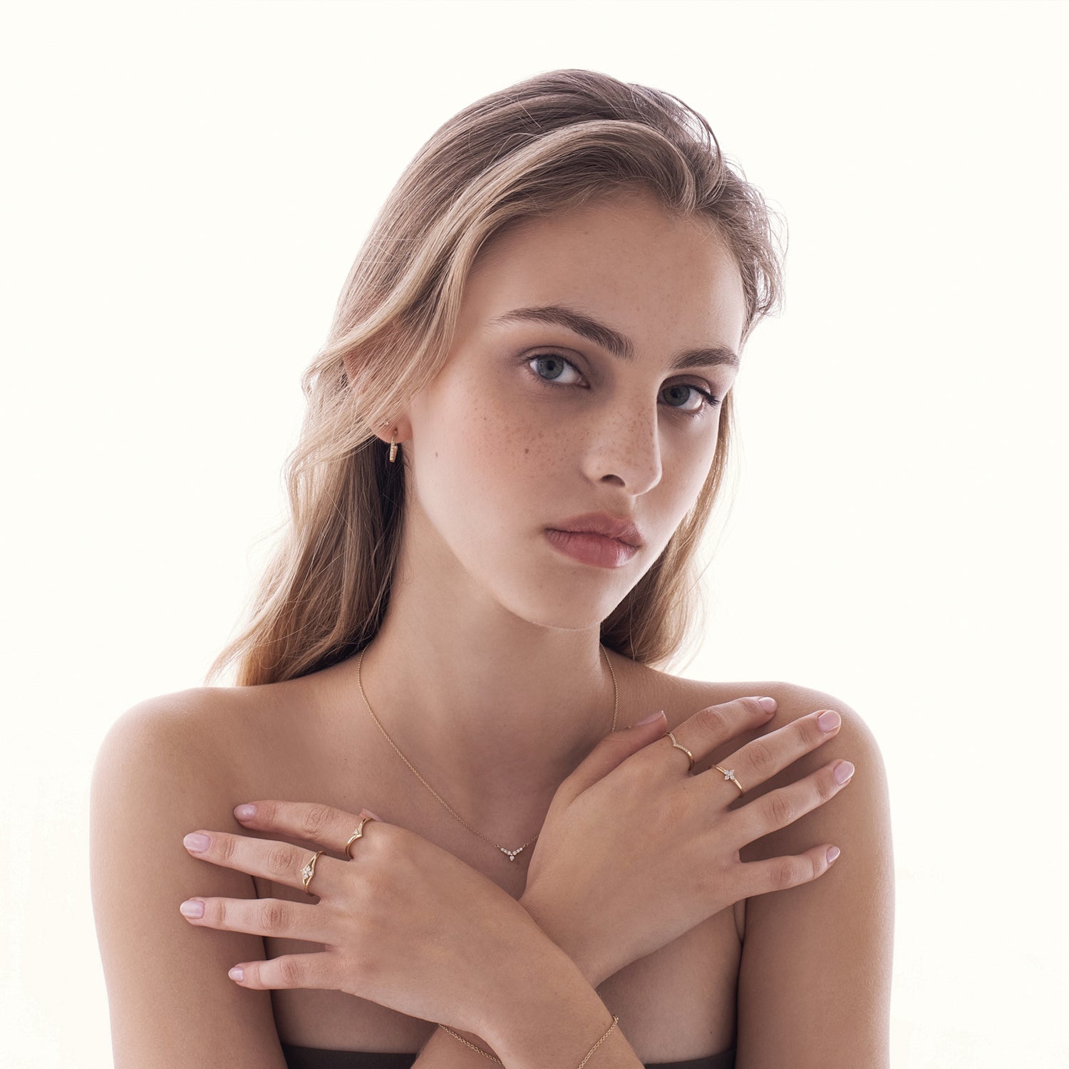 A gold necklace with a V-shaped pendant studded with diamonds reminiscent of a flower