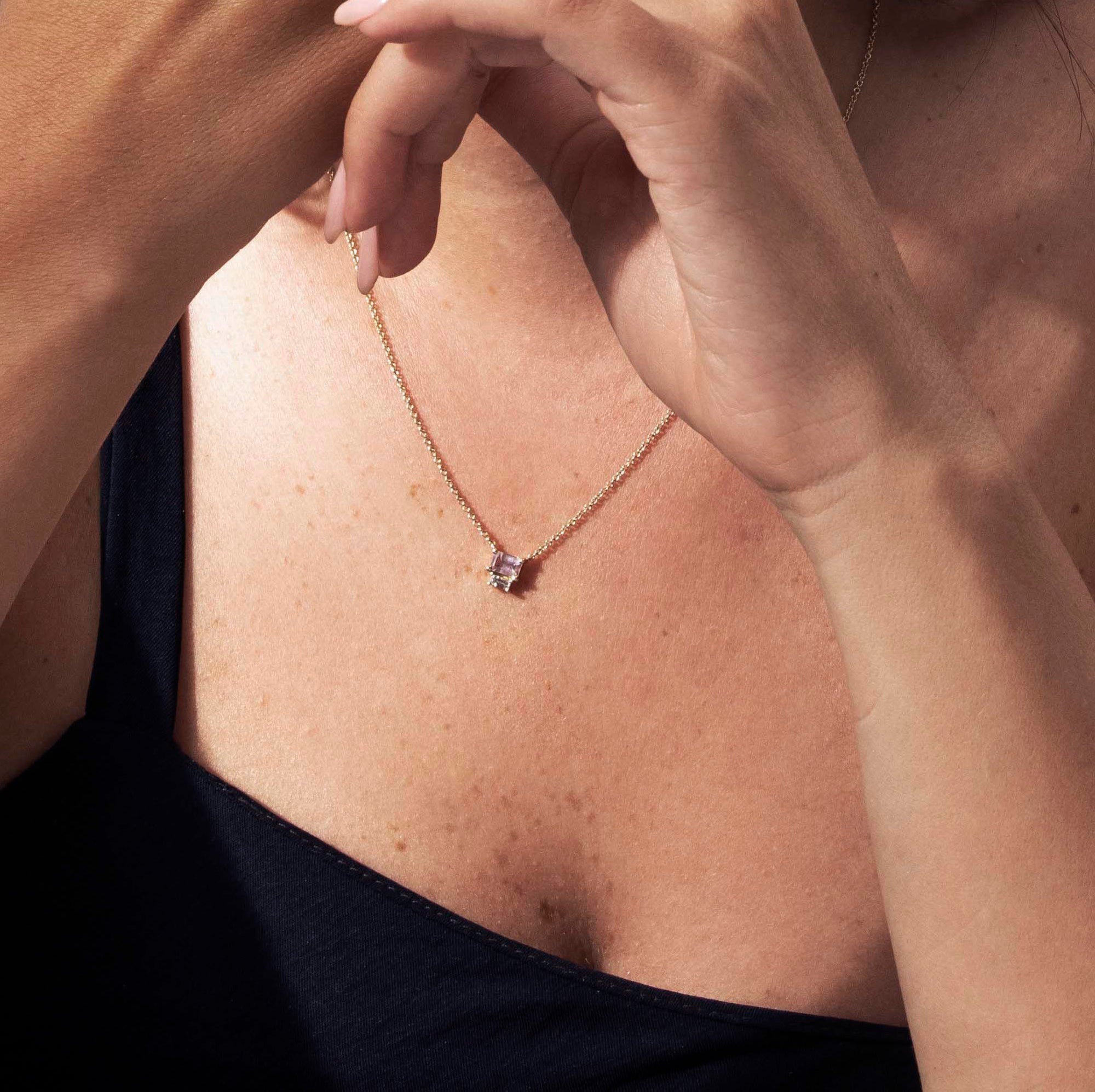 Gold necklace with pendant inlaid with emerald cut emeraldcut and baguette diamond