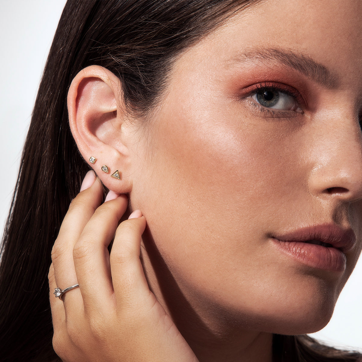 Small attached round diamond earrings in a marquise frame