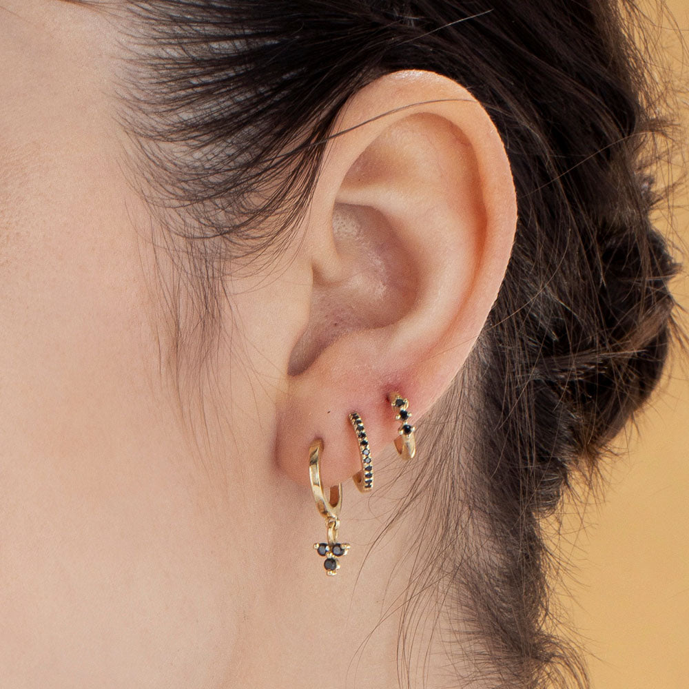 Gold hoop earrings with a pendant studded with 3 black diamonds