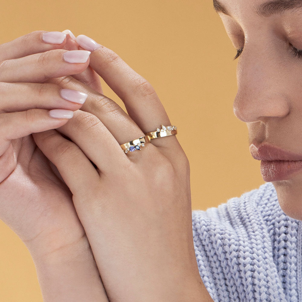 A wide gold ring with a special asymmetric setting of tanzanite, sapphire and diamonds