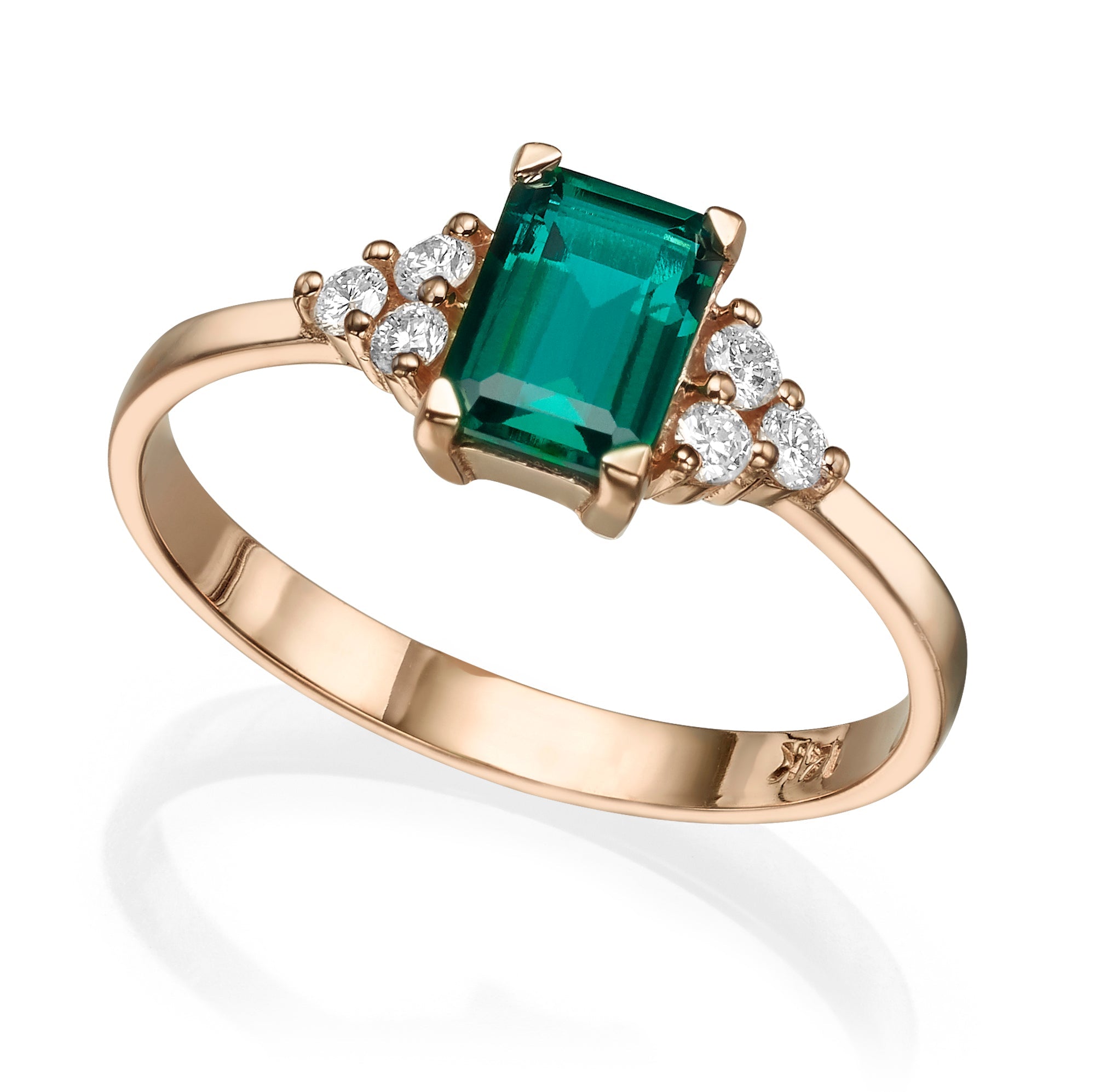 An engagement ring set with a rectangular lab emerald and 6 sided diamonds