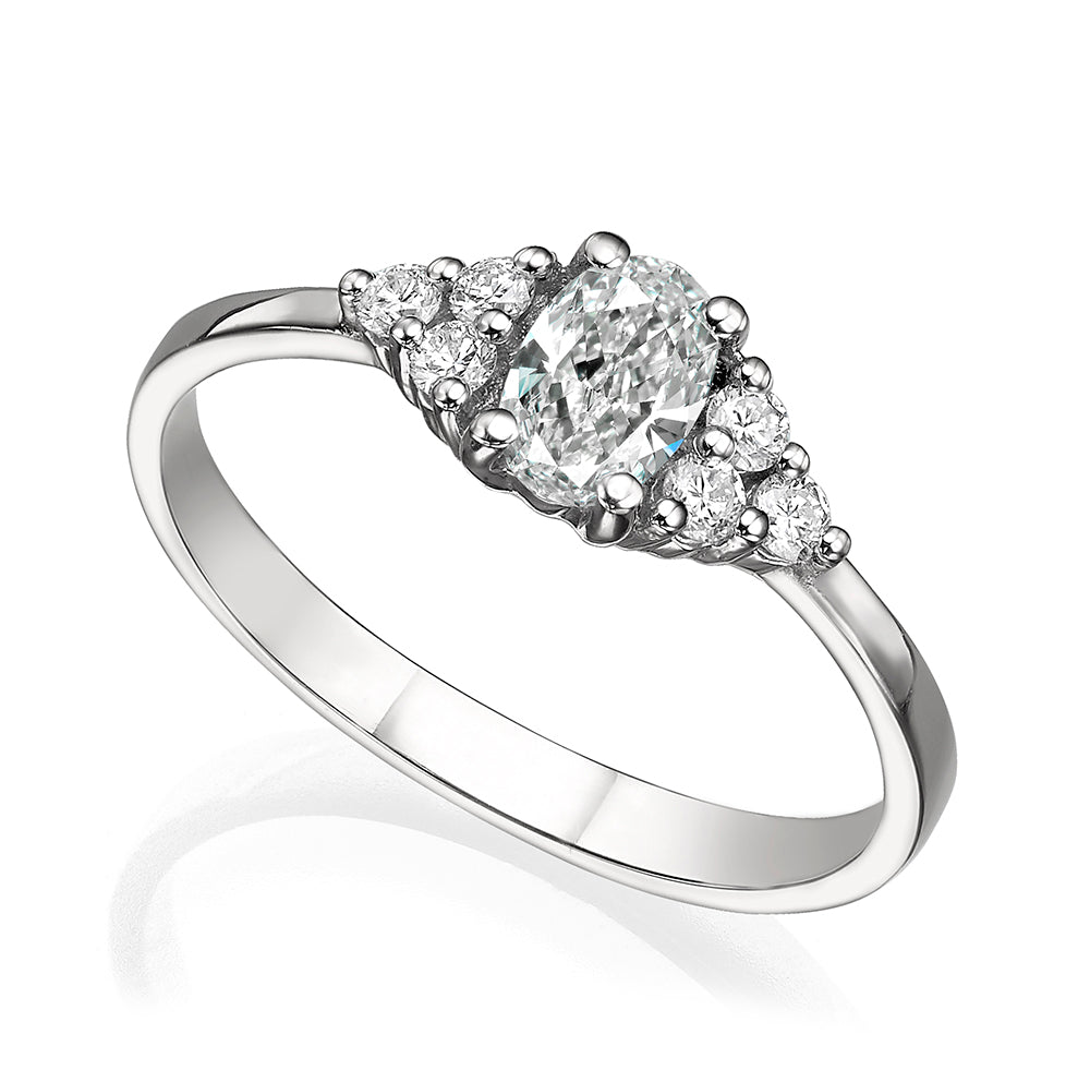 An engagement ring set with a central oval diamond and 6 side diamonds