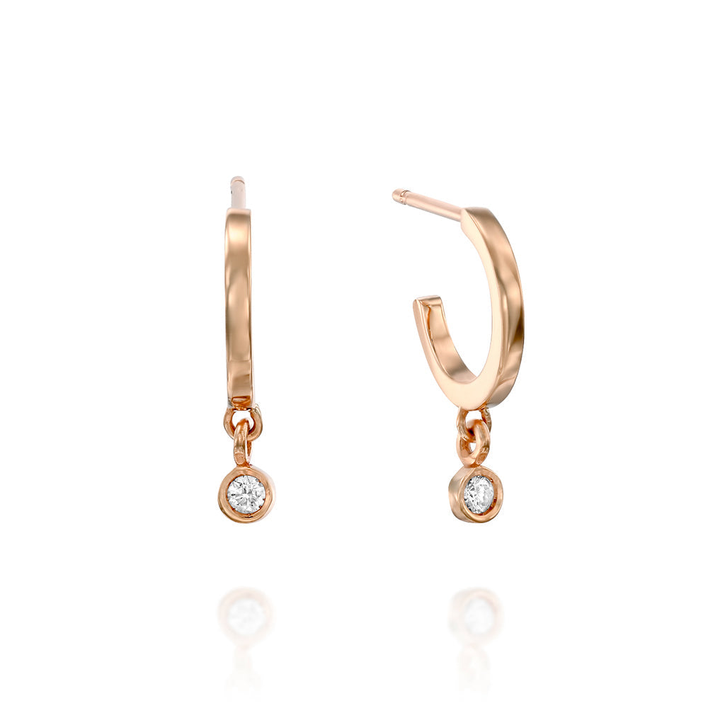 Small gold hoop earrings with a 4-point diamond pendant in a gold frame