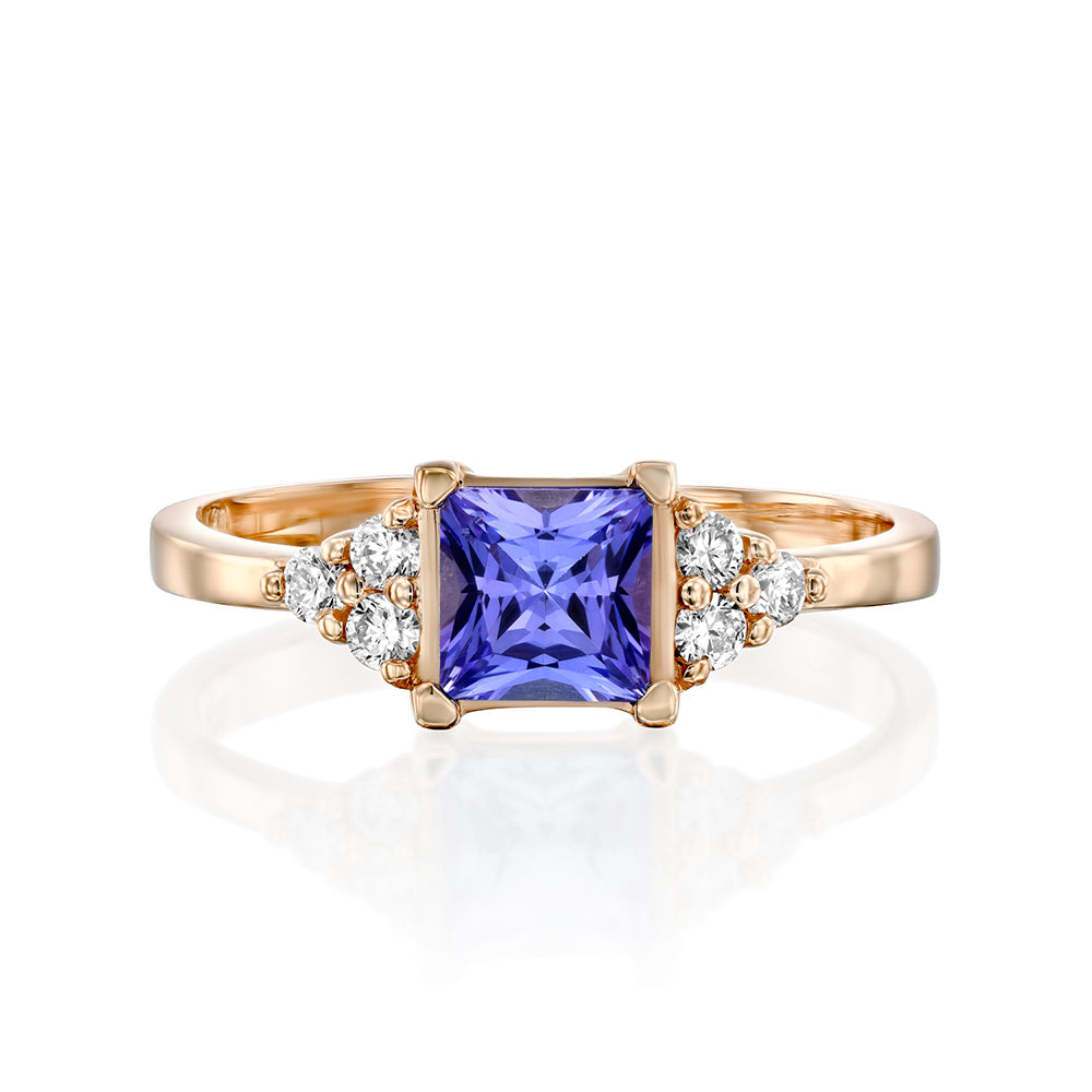 A gold ring set with Tanzanite Princess and 6 sided diamonds
