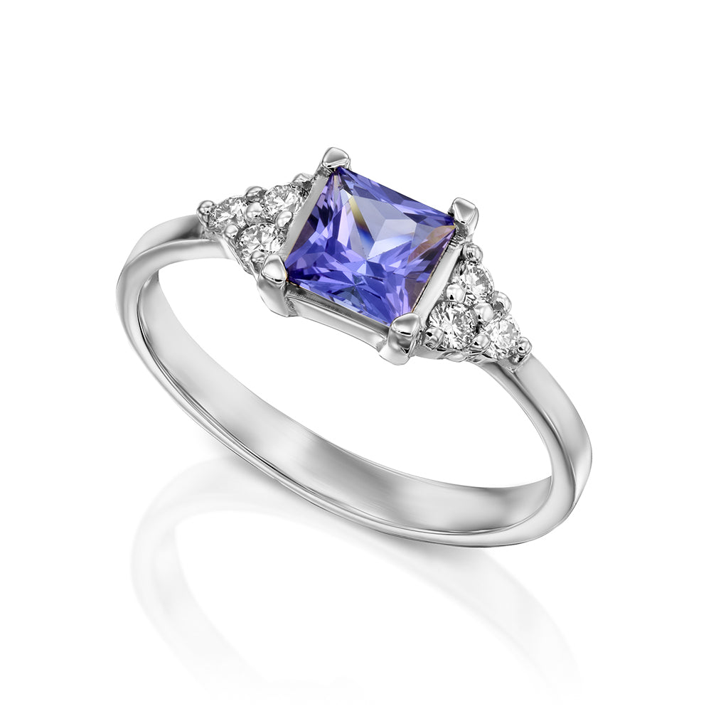 A gold ring set with Tanzanite Princess and 6 sided diamonds