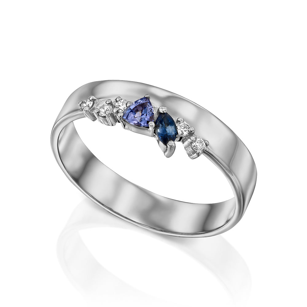 A wide gold ring with a special asymmetric setting of tanzanite, sapphire and diamonds