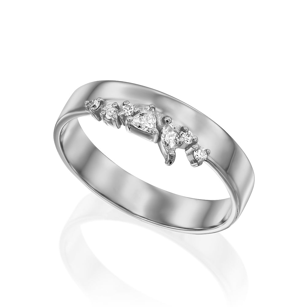 A wide gold ring with a special asymmetric setting of diamonds in a variety of cuts
