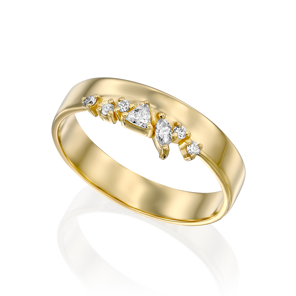 A wide gold ring with a special asymmetric setting of diamonds in a variety of cuts