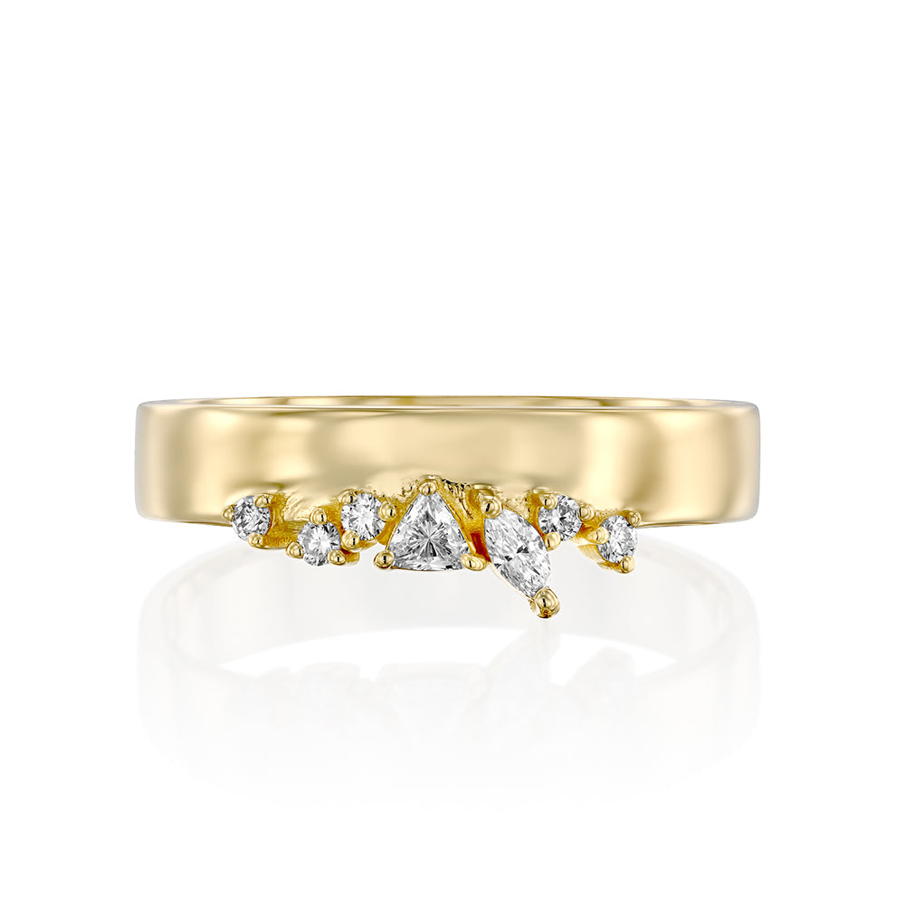 A wide gold ring with a special asymmetric setting of diamonds in a variety of cuts