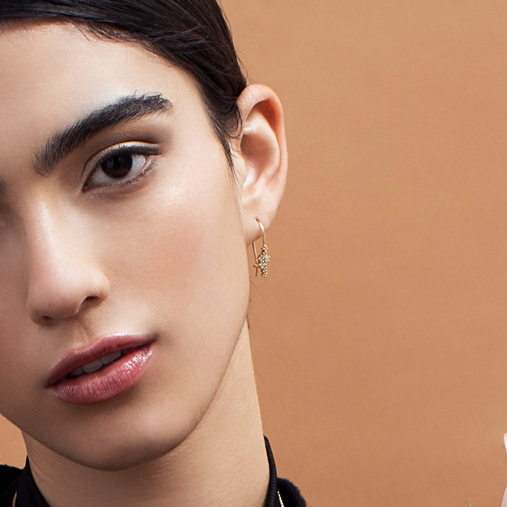 Hanging gold earrings studded with diamonds of varying sizes