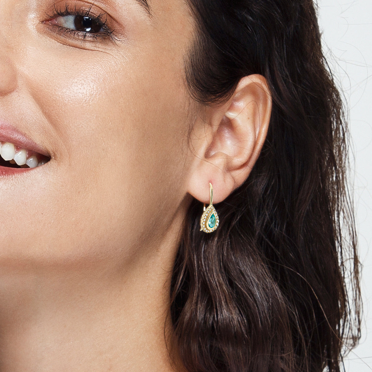 Hanging gold earrings studded with blue topaz and diamonds