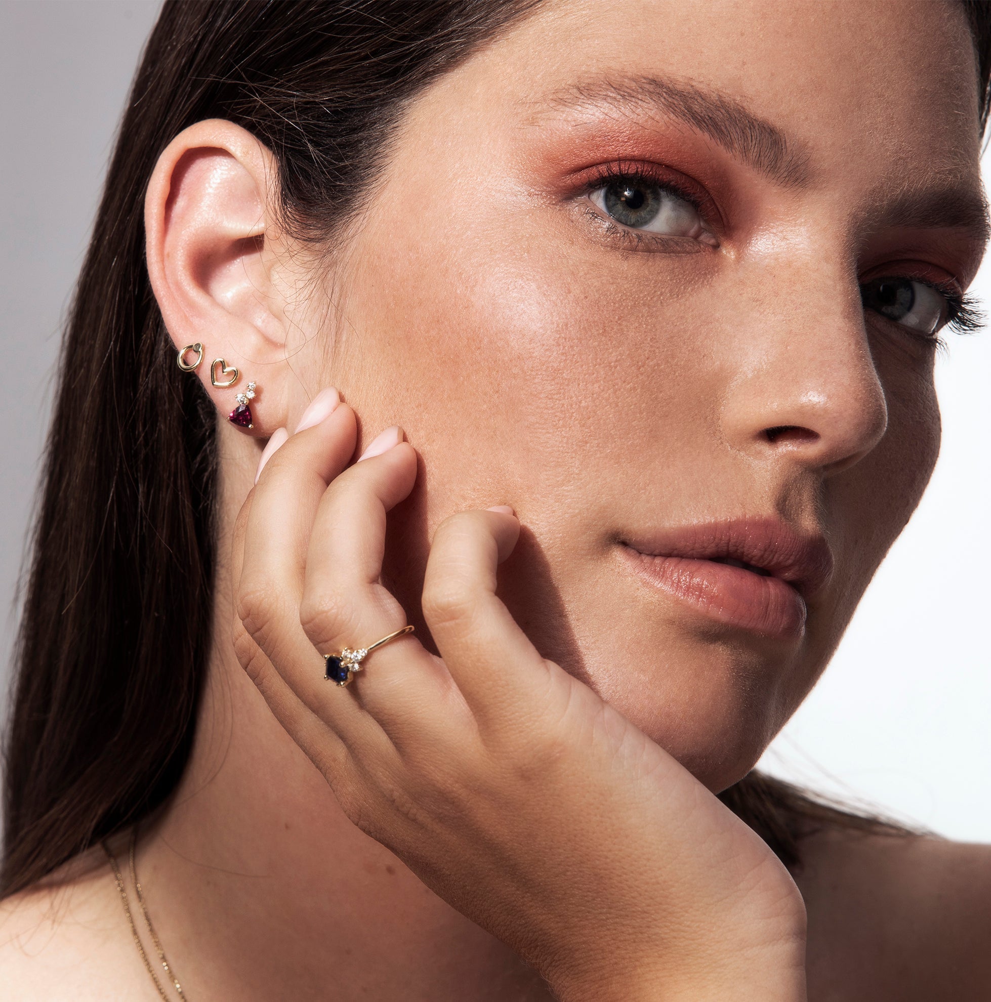 Gold earrings close to the ear in the design of small hearts