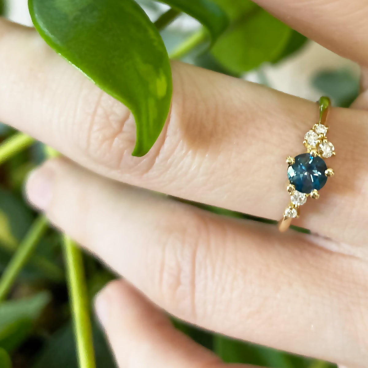 An engagement ring set with London blue topaz and small one-centimeter diamonds
