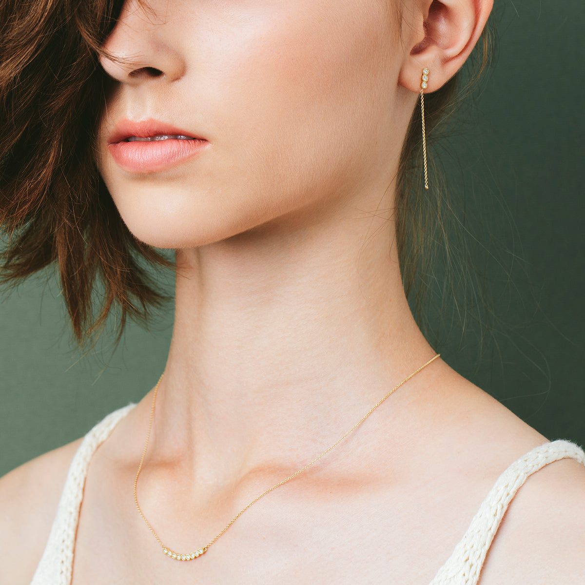 Attached white diamond earrings with a gold chain