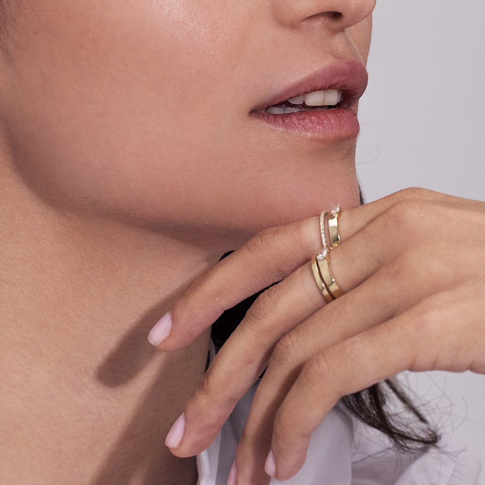 A double gold ring set with a row of diamonds and a drop-cut diamond weighing 10 points