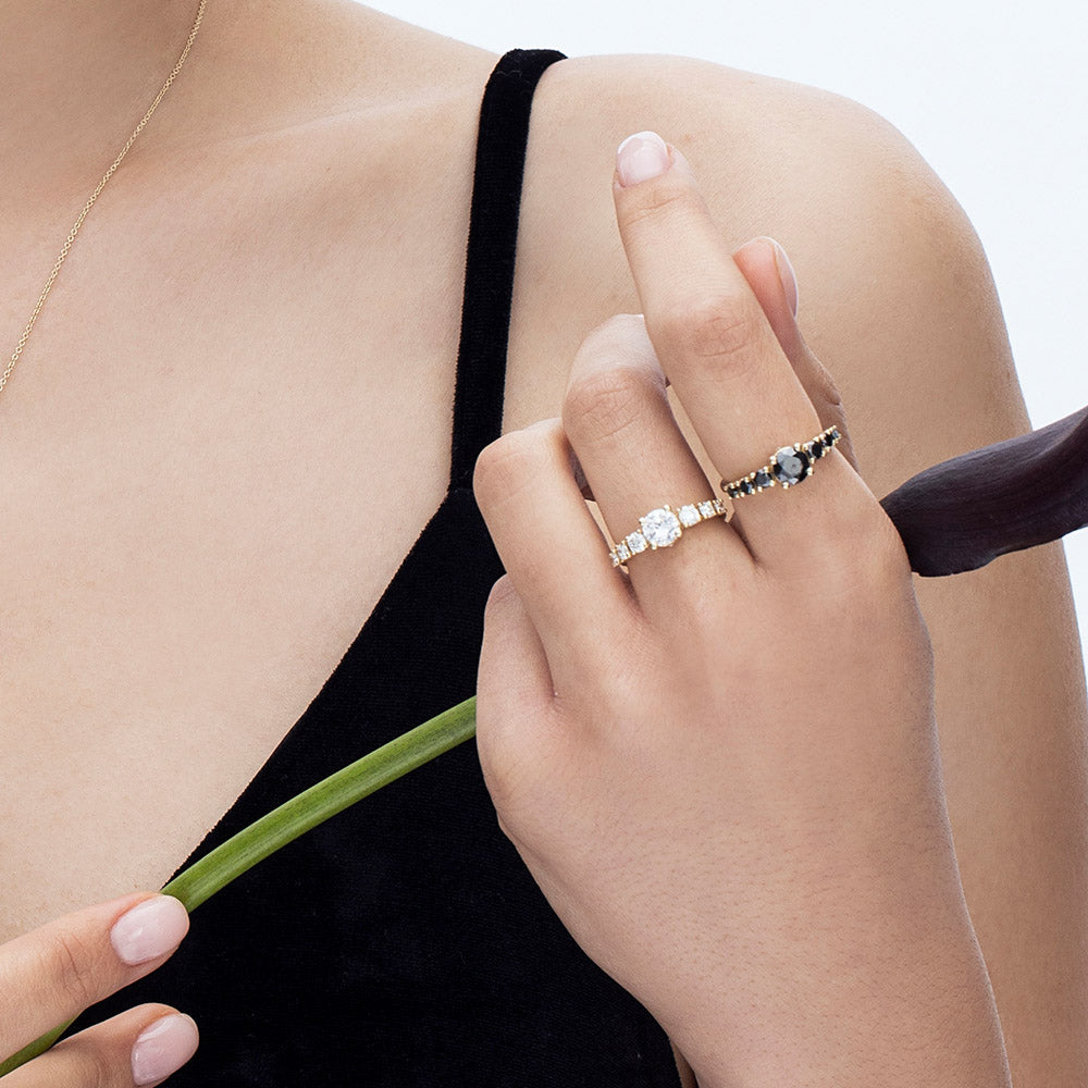 A black diamond ring for a woman set with a 1 carat central diamond and 6 side black diamonds