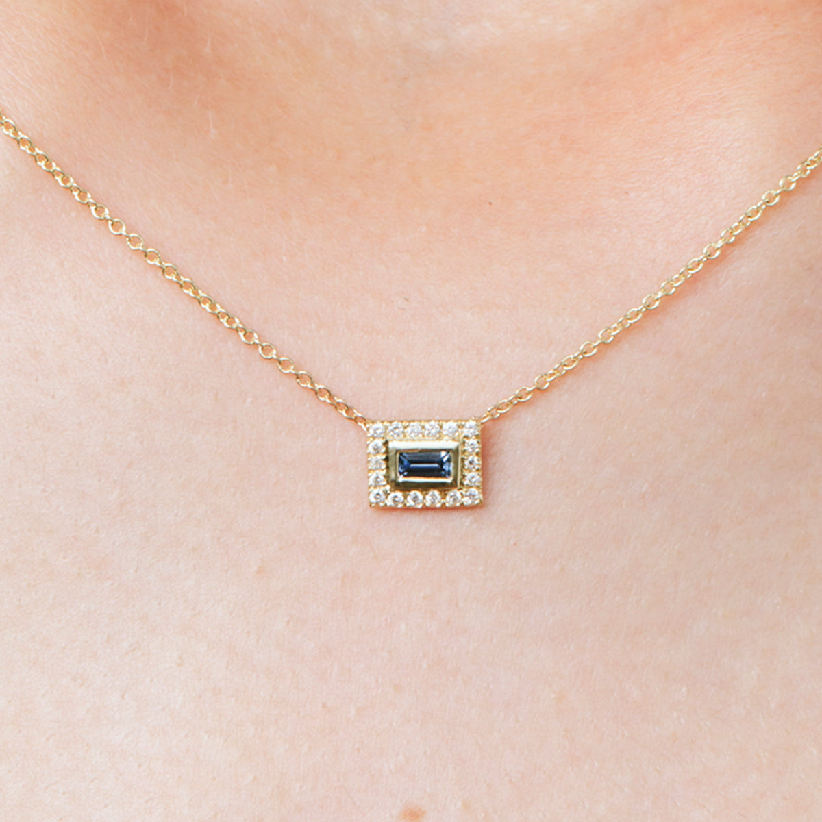 A baguette cut gold chain studded with diamonds and sapphires