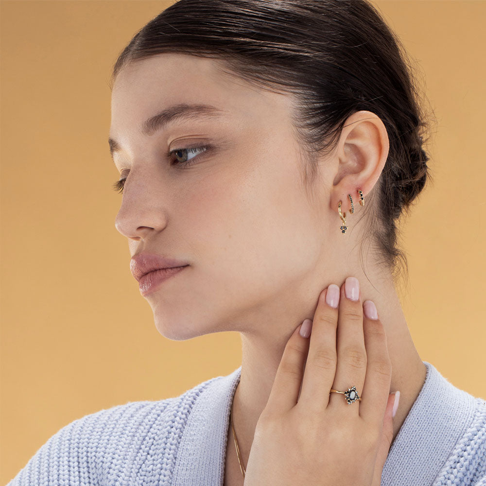 Gold hoop earrings with a pendant studded with 3 black diamonds