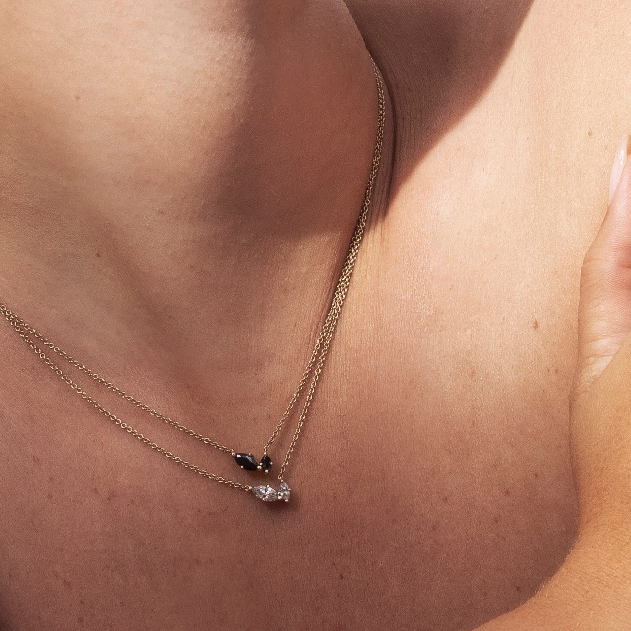 A delicate gold chain inlaid with two marquise-cut black diamonds of different sizes