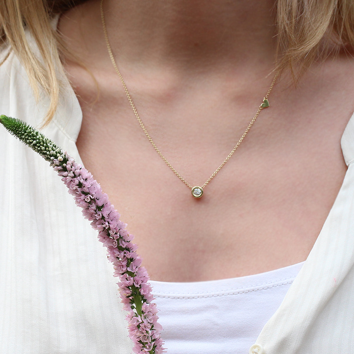 A 30 point lab diamond studded gold chain with a heart pendant on the side