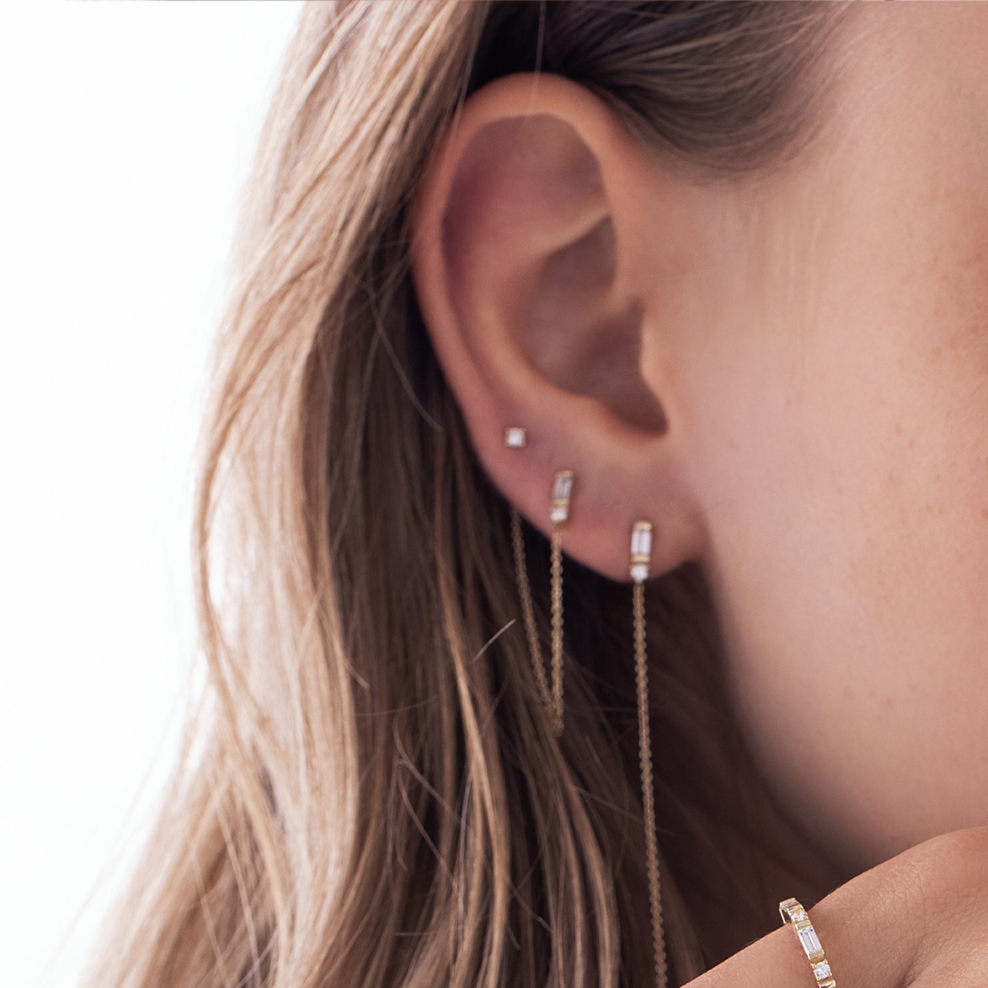 A special gold chain earring set with lab diamonds in a baguette and circle cut