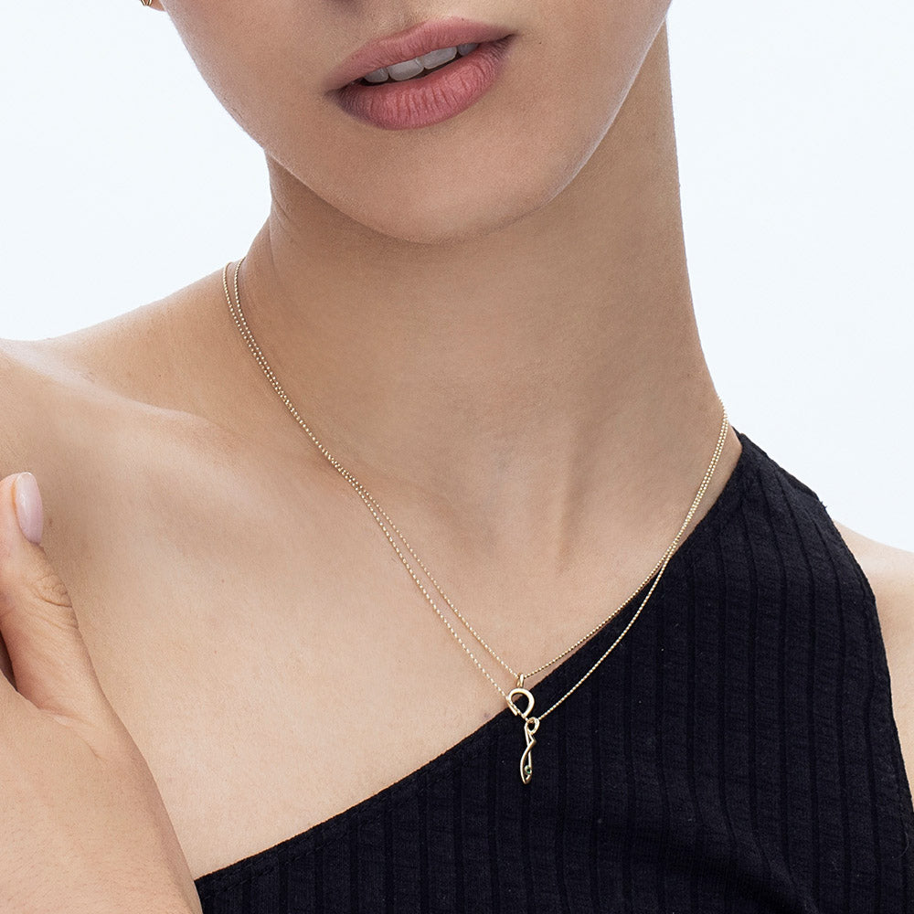 Gold necklace with an emerald-studded fish pendant