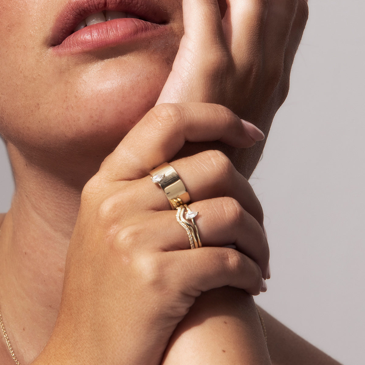 A wide gold ring set with a drop cut diamond
