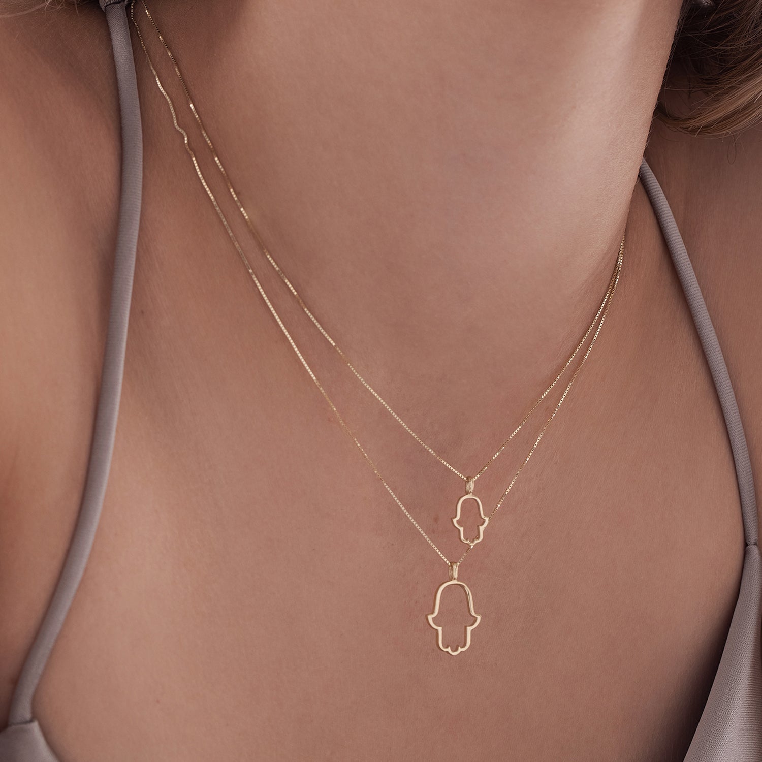 Hamsa gold necklace for women with a small outline
