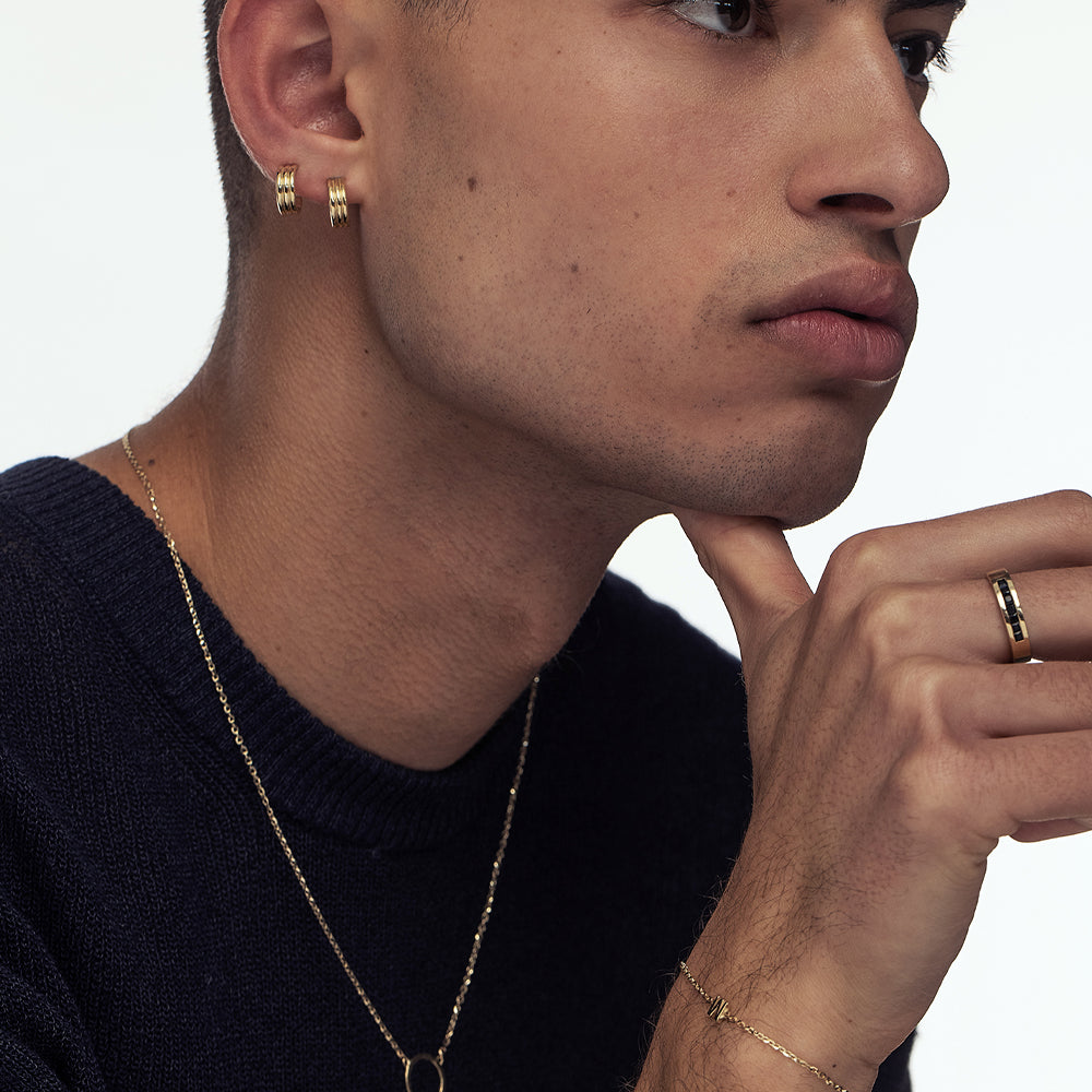 A wide gold ring for men inlaid with onyx in a line princess cut