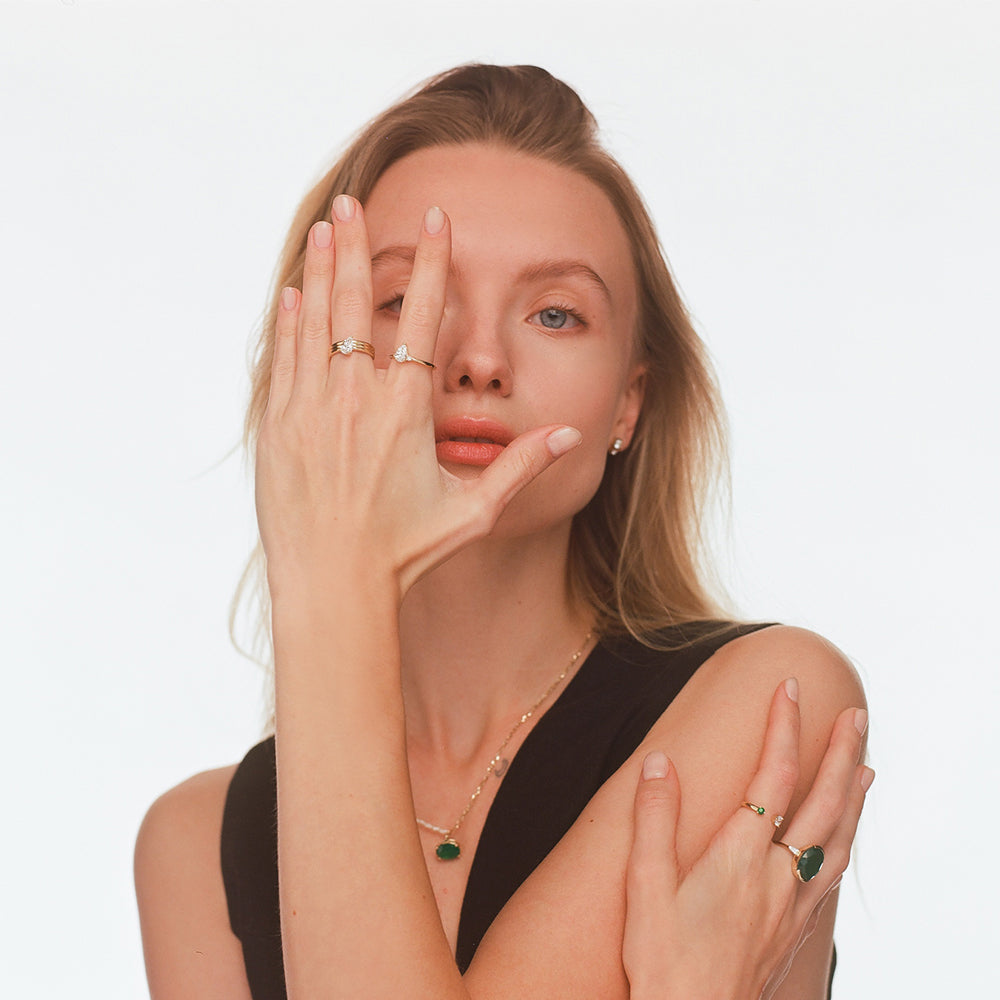 A wide gold ring set with a drop-cut lab diamond