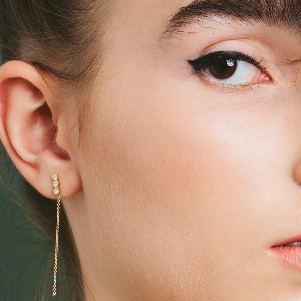 Attached white diamond earrings with a gold chain