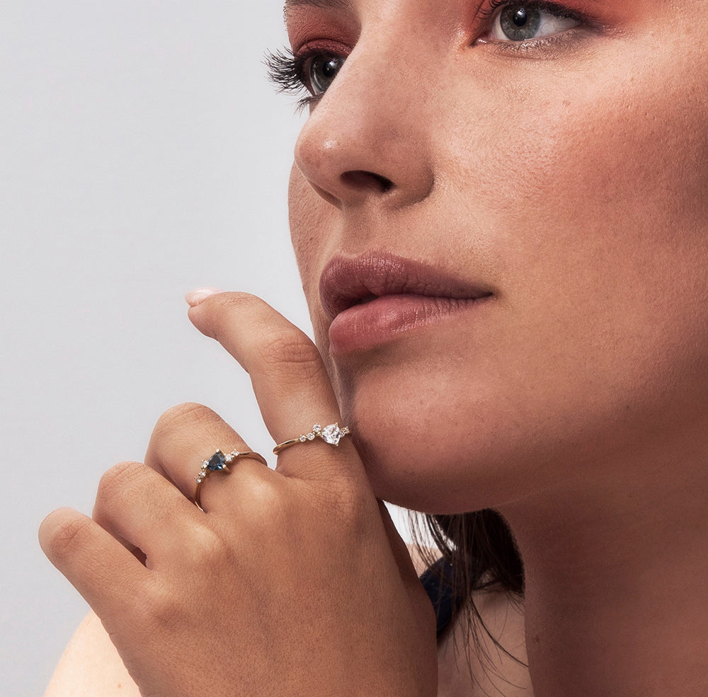 An engagement ring set with a trillion-cut sapphire and diamonds all around