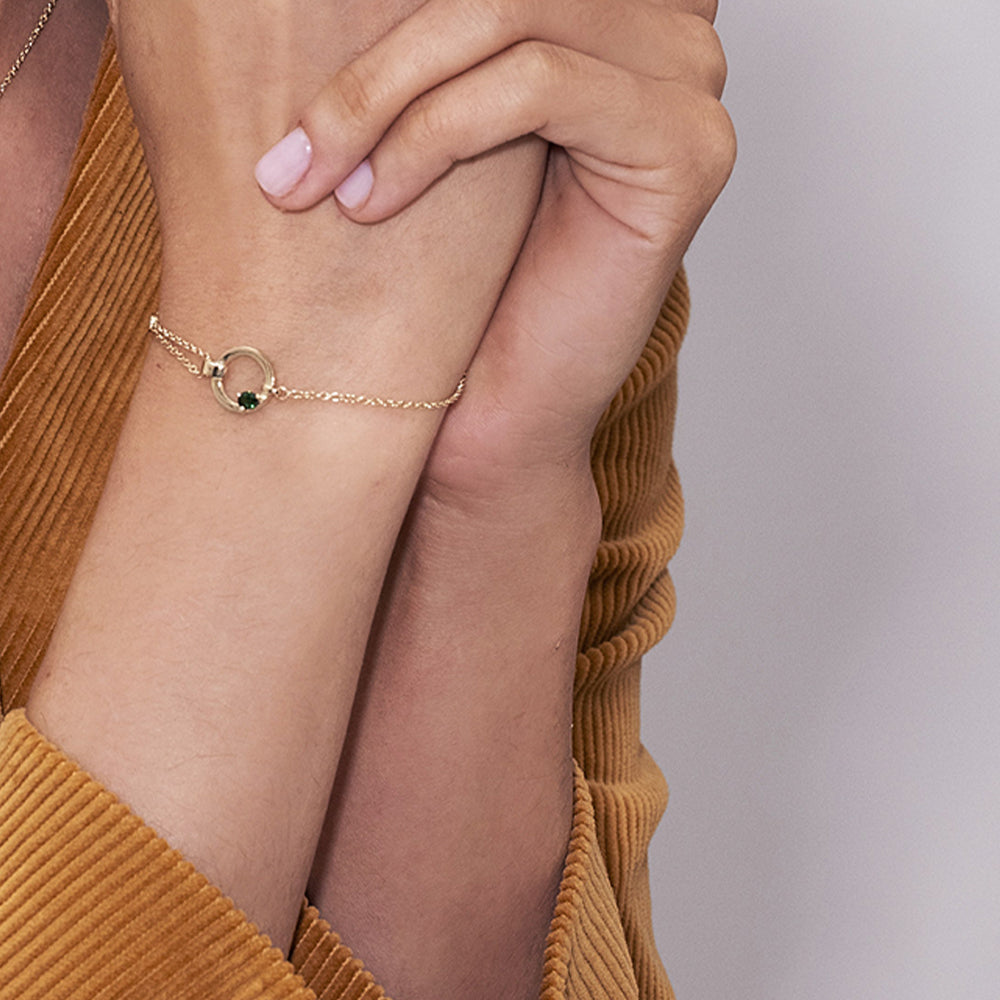 A special asymmetric gold bracelet, in a modern and impressive design. Inlaid green tourmaline and diamond.