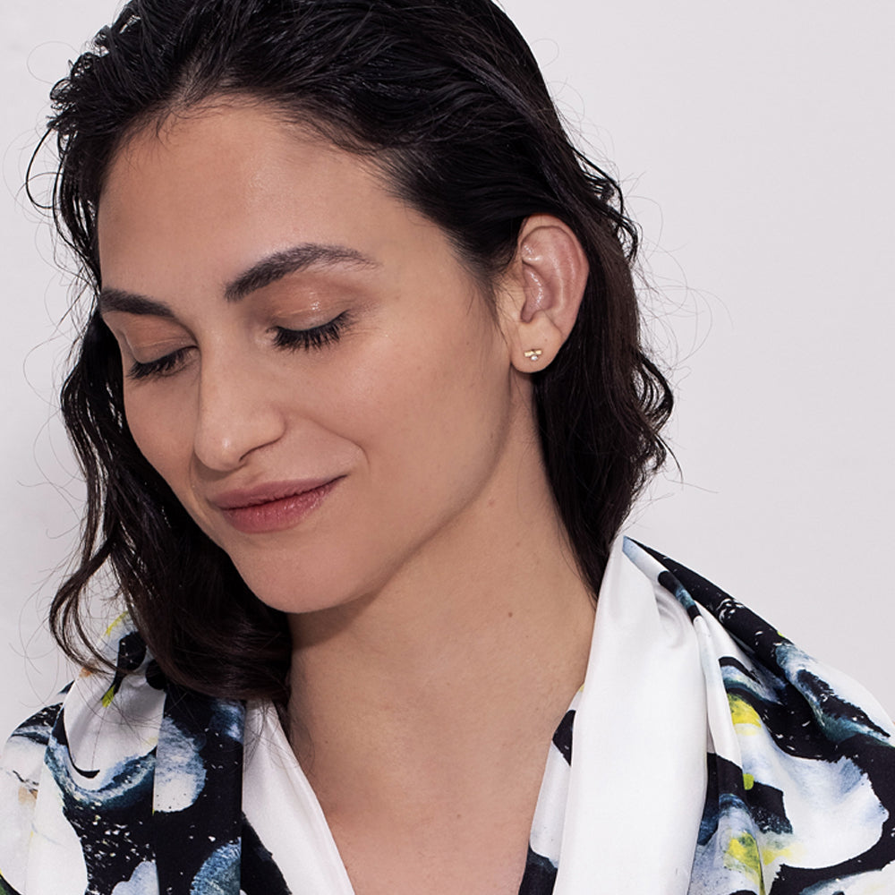 Gold earrings, tight, small, in the form of a stripe, set with a diamond