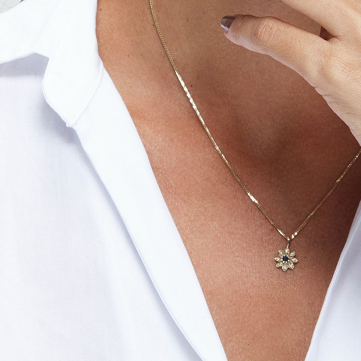 Gold necklace with a flower studded with diamonds and sapphires