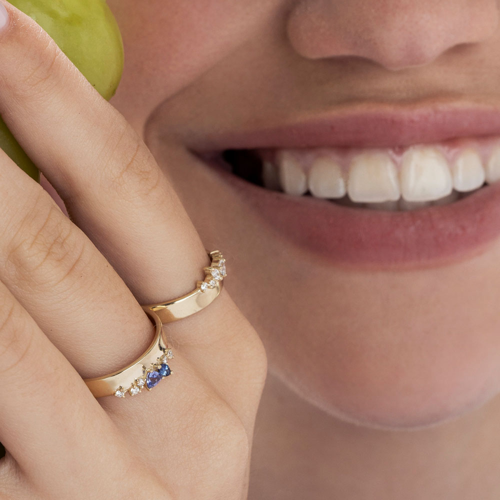 A wide gold ring with a special asymmetric setting of tanzanite, sapphire and diamonds