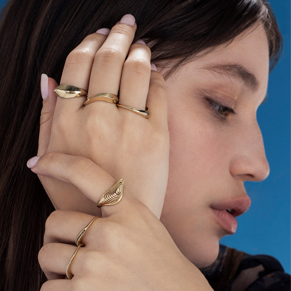 A thick geometric wave-shaped gold ring