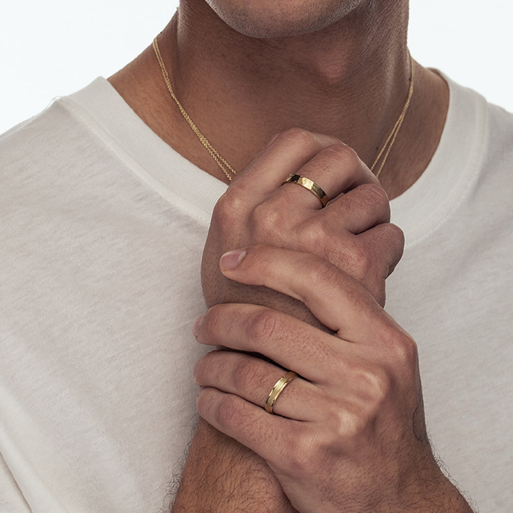 A wedding ring for a man and a woman: a flat gold ring with a fine braided texture, 4 mm wide