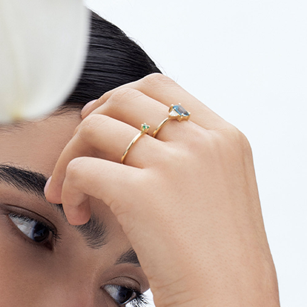Gold ring set with light London blue topaz and trillion-cut diamonds on the sides